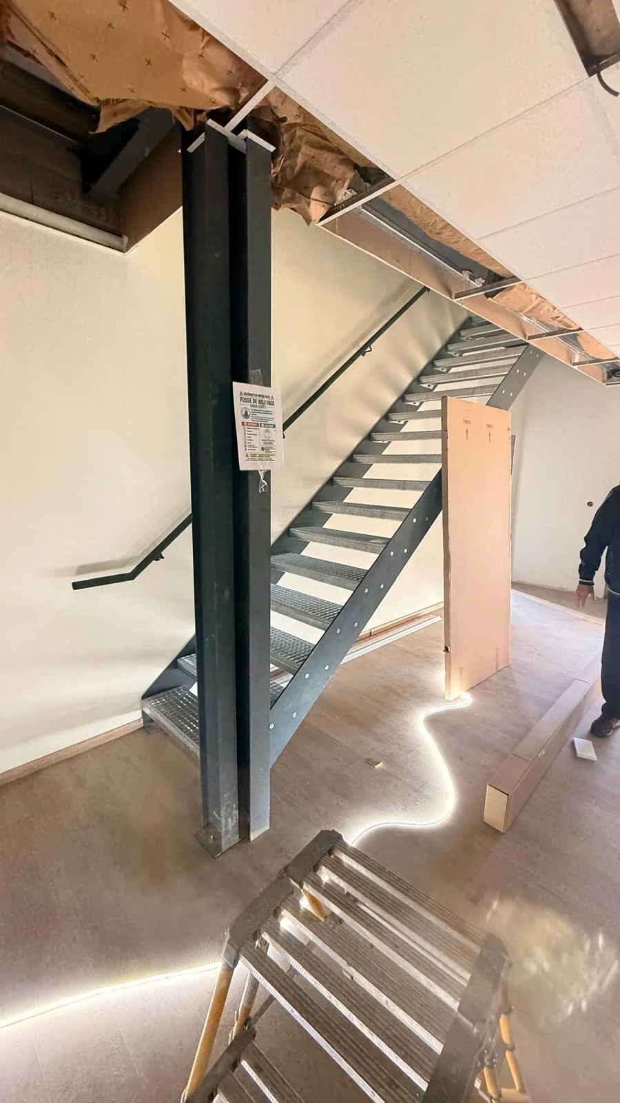 Escalier métallique menant à une mezzanine dans un local professionnel rénové