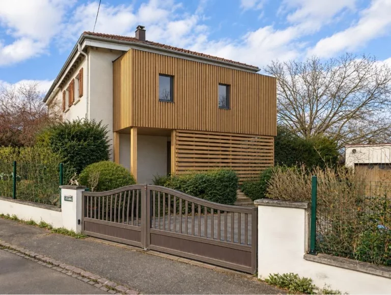 Extension à étage en ossature bois avec bardage à claire-voie, accolée à une maison