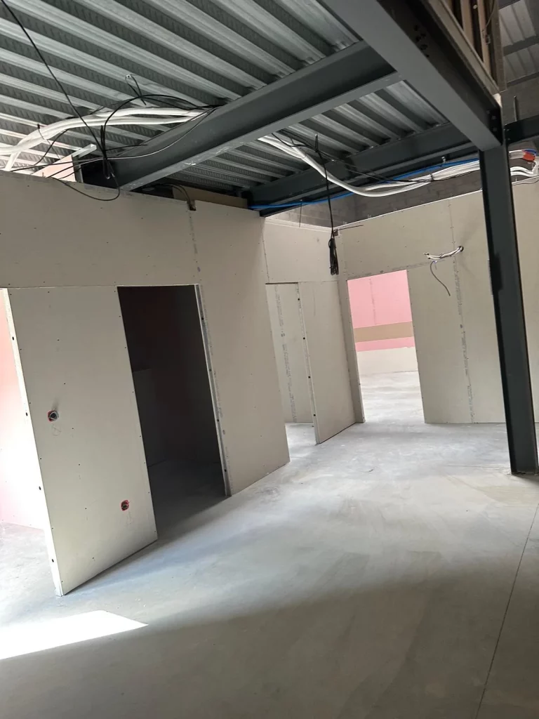Cloisons en plaques de plâtre sous une mezzanine métallique dans un local professionnel