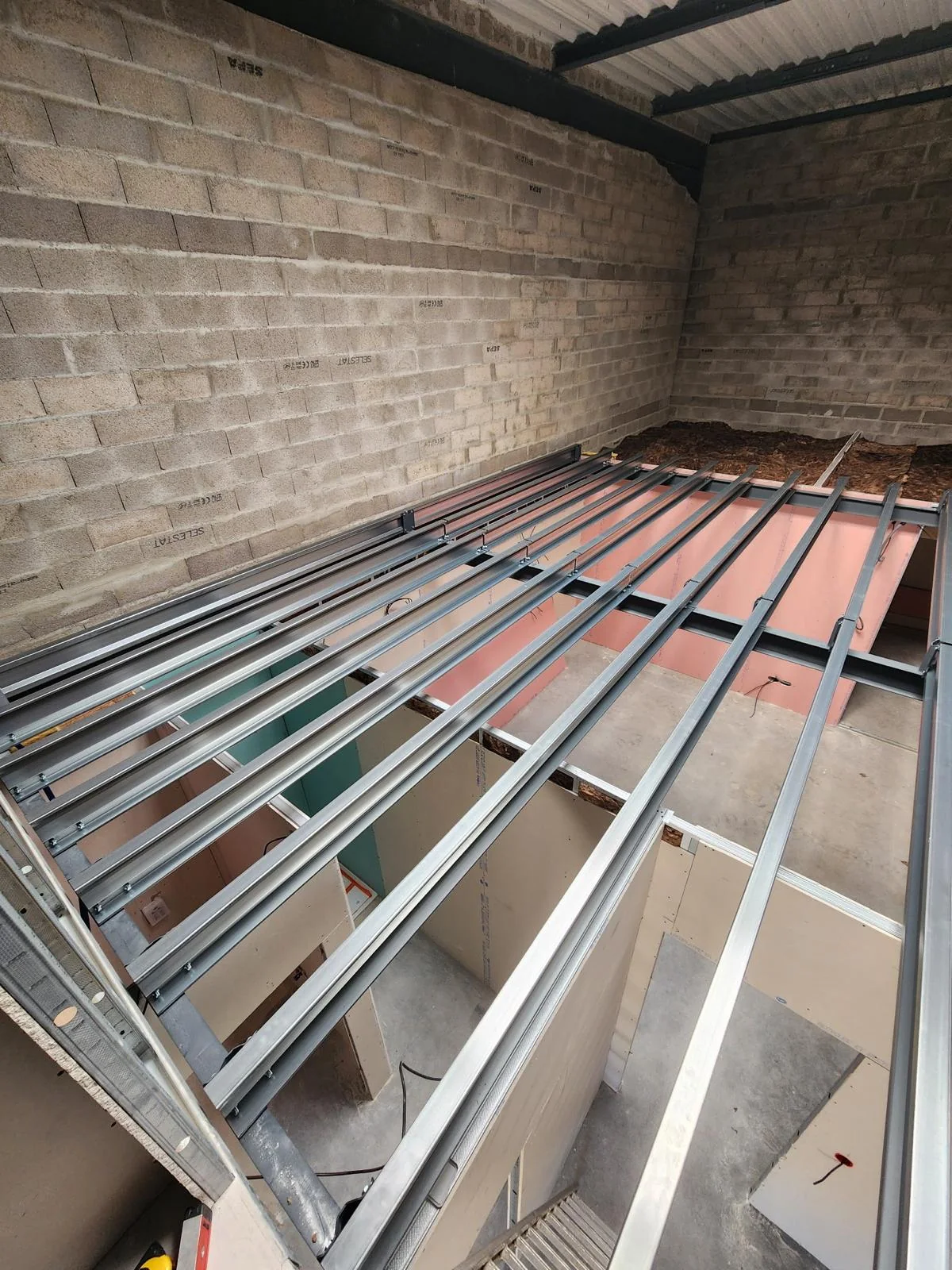 Structure de mezzanine en acier posée dans un local professionnel, avant pose du plancher
