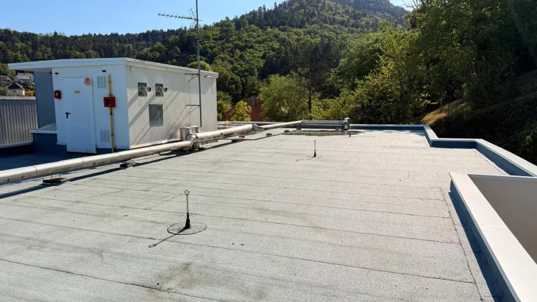 Toiture-terrasse d’un bâtiment avec étanchéité, vue sur les collines