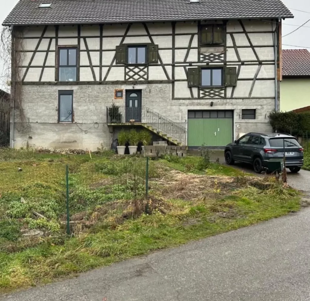 Maison alsacienne à colombages avant la rénovation de sa façade et l'aménagement de son terrain en pente