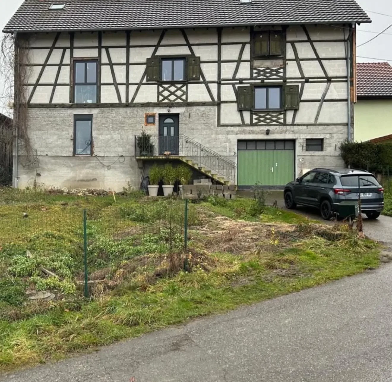 Maison alsacienne à colombages avant la rénovation de sa façade et l'aménagement de son terrain en pente