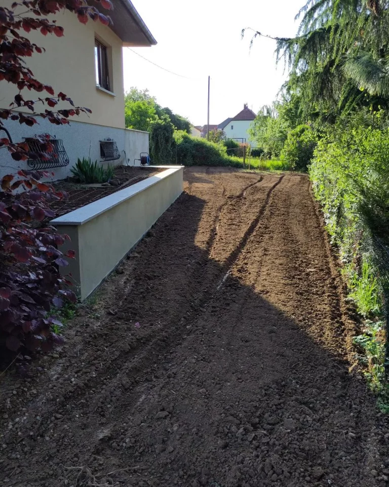 Terrain nivelé le long d’une maison, bordé par un mur de soutènement neuf