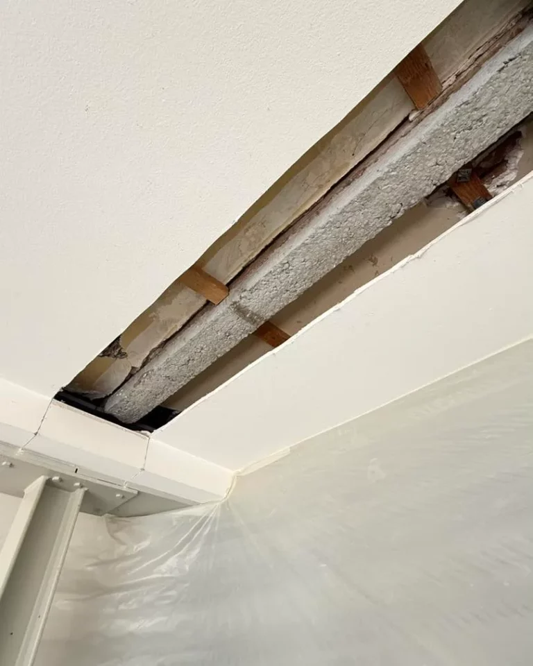 Plafond ouvert lors d'une reprise de charge après un sinistre, poutre en béton apparente