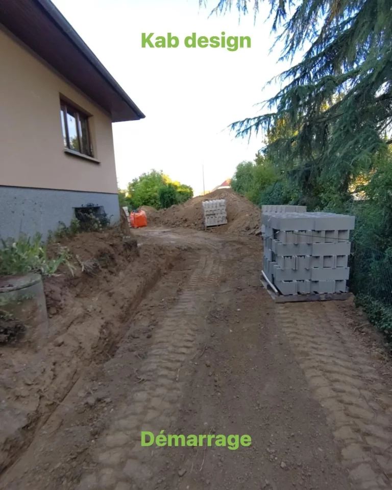Démarrage d'un terrassement le long d'une maison, avec des palettes de blocs béton prêtes à poser